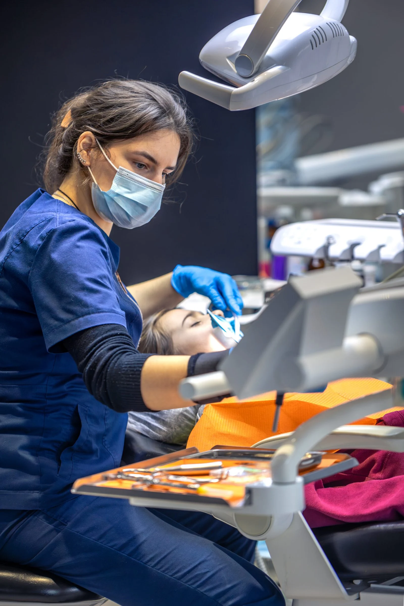 A professional providing dental care in a clinical setting